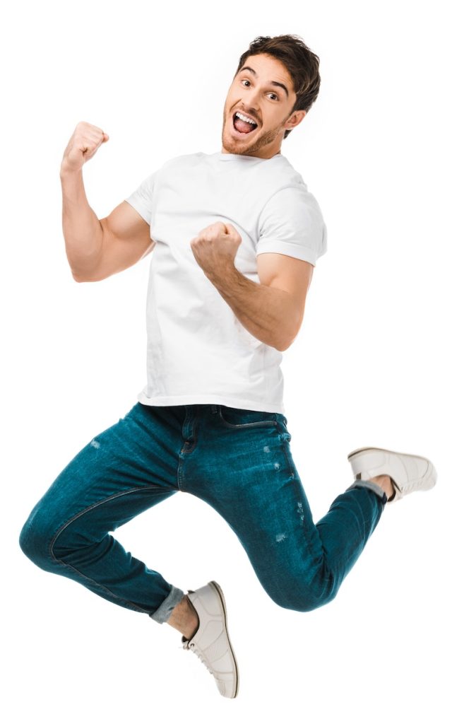 excited young man jumping and smiling at camera isolated on white