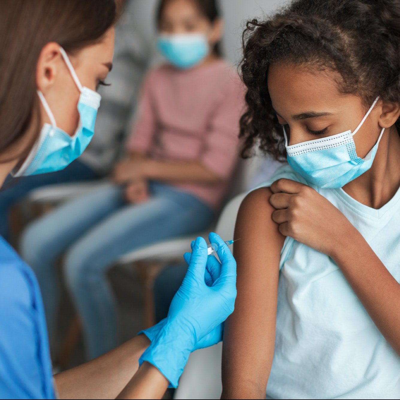 Nurse Vaccinating Black Preteen Girl Injecting Vaccine Against Covid-19 Indoors